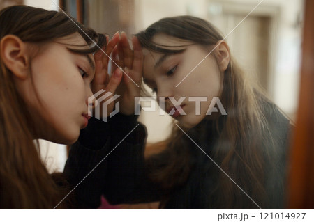 Close-up of pensive young woman leaning against mirror Close-up of pensive young woman leaning against mirror 121014927