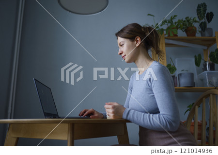 Woman using laptop at home 121014936