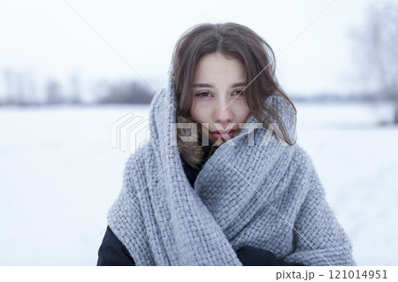 Portrait of woman wrapped in wool shawl in snowy landscape 121014951
