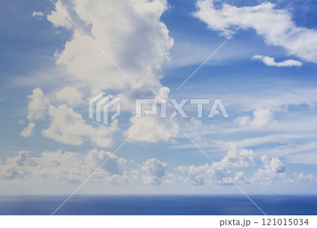 White puffy clouds above calm sea 121015034