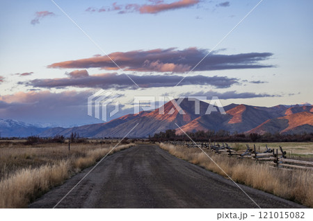 Empty dirt road leading to foothills at sunset 121015082