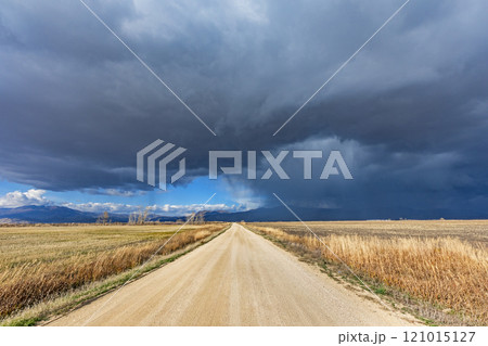Storm clouds over empty dirt road in rural landscape 121015127