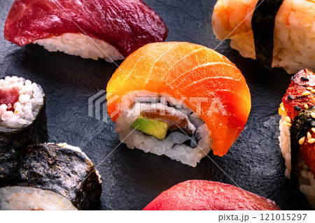 Sushi rolls on a black background. Uramaki with salmon and avocado 121015297