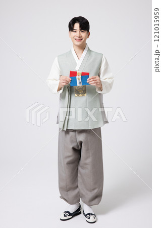 Portrait of a young man wearing hanbok and holding a luxury gift certificate 121015959