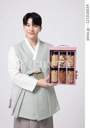 Portrait of a young man wearing hanbok and opening a gift box 121016034