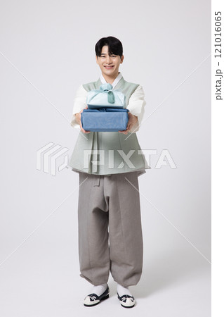 Portrait of a young man wearing hanbok and holding a luxurious holiday gift Portrait of a young man wearing hanbok and holding a luxurious holiday gift 121016065