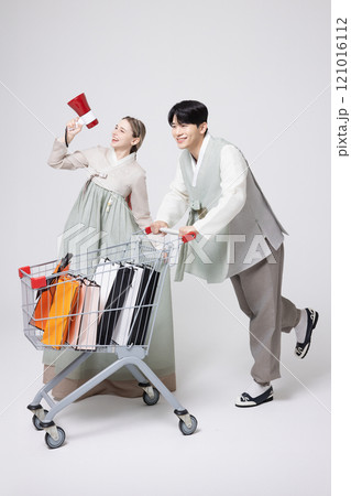 A Korean man wearing a hanbok and shopping with a shopping cart and a foreign woman holding a loudspeaker A Korean man wearing a hanbok and shopping with a shopping cart and a foreign woman holding a loudspeaker 121016112