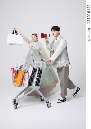 A Korean man wearing a hanbok and shopping with a shopping cart and a foreign woman carrying shopping bags A Korean man wearing a hanbok and shopping with a shopping cart and a foreign woman carrying shopping bags 121016123