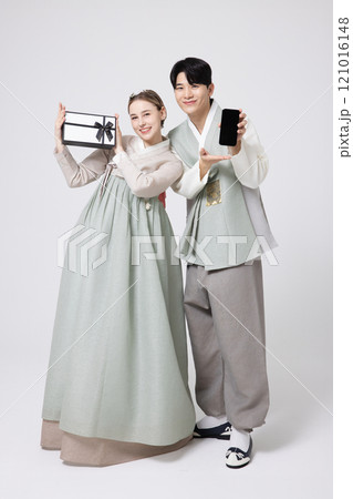 A foreign woman and a Korean man wearing hanbok and holding carefully prepared gifts A foreign woman and a Korean man wearing hanbok and holding carefully prepared gifts 121016148