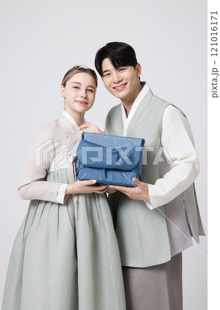 A foreign woman and a Korean man wearing hanbok and holding carefully prepared gifts A foreign woman and a Korean man wearing hanbok and holding carefully prepared gifts 121016171