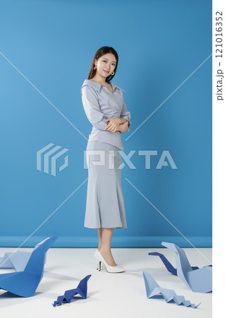 Portrait of a woman standing and posing in front of a blue snake folded out of paper Portrait of a woman standing and posing in front of a blue snake folded out of paper 121016352