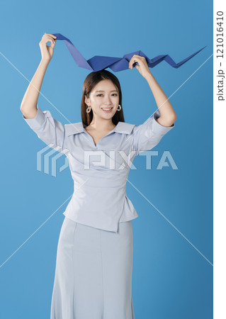 Woman posing with a blue snake folded out of paper Woman posing with a blue snake folded out of paper 121016410