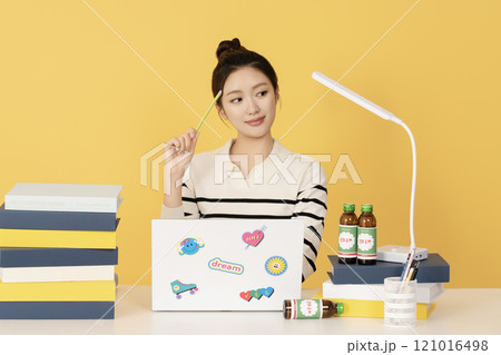 A college student studying with his laptop open 121016498