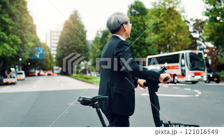 Business, man and walking with e bike in city for sustainable transport, eco friendly and carbon neutral travel. Mature person, electric bicycle and morning commute, urban journey and Japan adventure 121016549