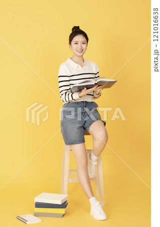 A college student wearing casual clothes and reading A college student wearing casual clothes and reading 121016638