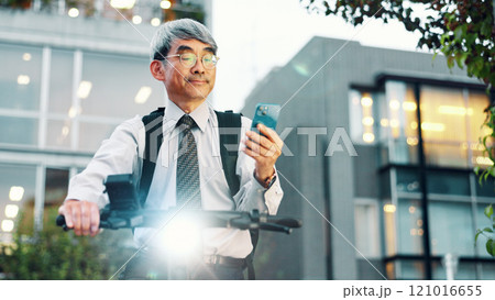 Businessman, phone or electrical bike in city for travel, clean energy or sustainable transport. Commute ride, mature or eco friendly scooter with mobile app technology for location or map in Japan 121016655