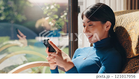 Woman, phone and texting in home, relax and check notification on web with smile in living room. Person, smartphone and happy with chat, scroll and mobile app for social network at house in Japan 121017056