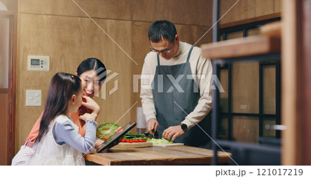 Parents, girl and tablet in home with cooking, learning and happy with food, tutorial and recipe in kitchen. People, mother and daughter with dad, touchscreen and meal prep at family house in Japan Parents, girl and tablet in home with cooking, learning and happy with food, tutorial and recipe in kitchen. People, mother and daughter with dad, touchscreen and meal prep at family house in Japan 121017219