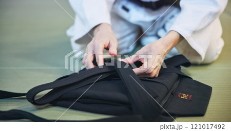 Person, hands and clothing with uniform for martial arts, fashion and aikido gi on floor in dojo. Japan, culture or black belt fighter with material, fabric or traditional outfit for self defense Person, hands and clothing with uniform for martial arts, fashion and aikido gi on floor in dojo. Japan, culture or black belt fighter with material, fabric or traditional outfit for self defense 121017492
