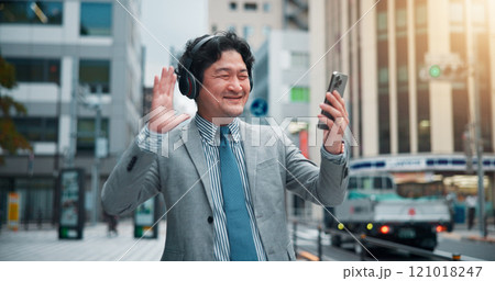 Asian man, headphones or wave with phone for video call, communication or commute in city. Japan, businessman or talking with mobile smartphone for virtual meeting, discussion or conversation in town 121018247