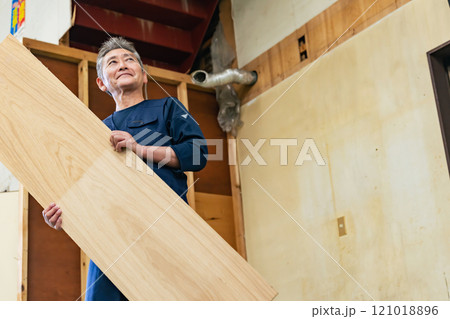 工事現場で材木を持つ大工 121018896