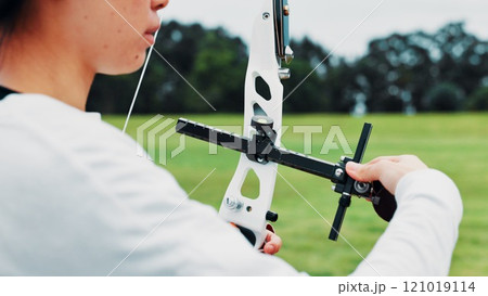 Woman, archery and hands at field as sport for shooting practice and training as athlete in Japan. Closeup, female person and setup recurve bow or equipment for challenge, game and competition 121019114
