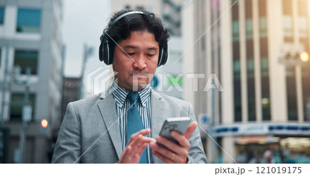 Business, man and phone with headphones in city for listening to music, travel guide and search playlist. Male person, mobile and podcast with morning commute, streaming radio and directions in Japan 121019175