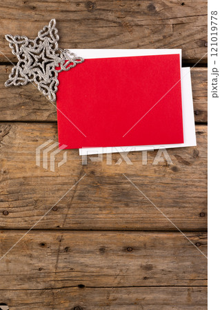 Vertical image of christmas star decoration, red and white cards, copy space on wooden background 121019778
