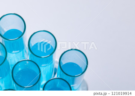 Close up of laboratory test tubes with blue liquid and copy space on white background 121019914