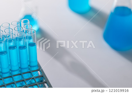 Close up of laboratory test tubes with blue liquid and copy space on white background Close up of laboratory test tubes with blue liquid and copy space on white background 121019916