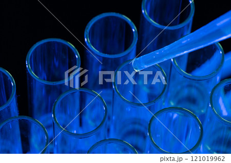 Close up of laboratory test tubes and pipette with copy space on blue background Close up of laboratory test tubes and pipette with copy space on blue background 121019962