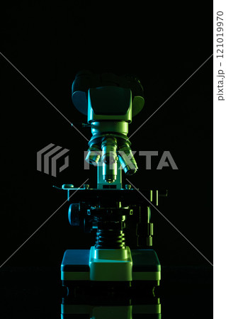Vertical image of laboratory microscope and copy space on black background 121019970