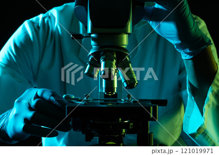 Scientist using microscope and copy space on black background 121019971