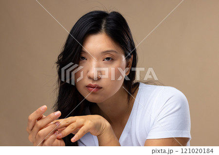 Portrait of asian woman wearing natural makeup and white t-shirt on beige background Portrait of asian woman wearing natural makeup and white t-shirt on beige background 121020184