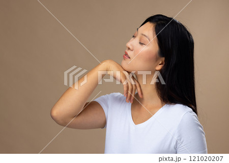 Asian woman wearing natural makeup and white t-shirt on beige background, copy space 121020207