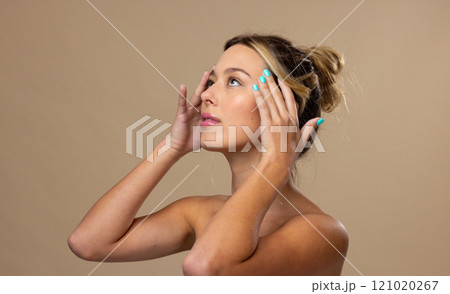 Caucasian woman wearing natural makeup and blue nail polish on beige background Caucasian woman wearing natural makeup and blue nail polish on beige background 121020267