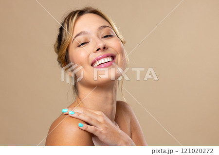 Portrait of caucasian woman wearing natural makeup and blue nail polish on beige background Portrait of caucasian woman wearing natural makeup and blue nail polish on beige background 121020272