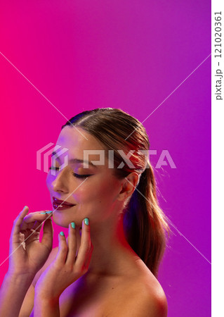 Caucasian woman wearing red lipstick and blue nail polish on purple background, copy space Caucasian woman wearing red lipstick and blue nail polish on purple background, copy space 121020361