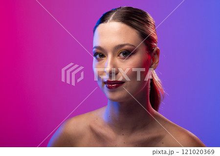 Portrait of caucasian woman wearing red lipstick and blue nail polish on purple background 121020369