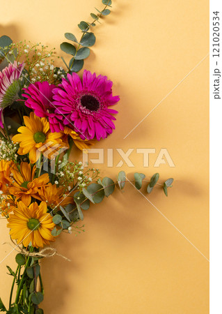 Vertical image of bunch of pink and yellow flowers with copy space on yellow background Vertical image of bunch of pink and yellow flowers with copy space on yellow background 121020534