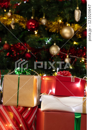 Vertical image of presents and christmas tree with baubles, decorations and copy space Vertical image of presents and christmas tree with baubles, decorations and copy space 121020647