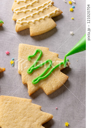 Vertical image of decorating of christmas cookies with copy space on grey background Vertical image of decorating of christmas cookies with copy space on grey background 121020704