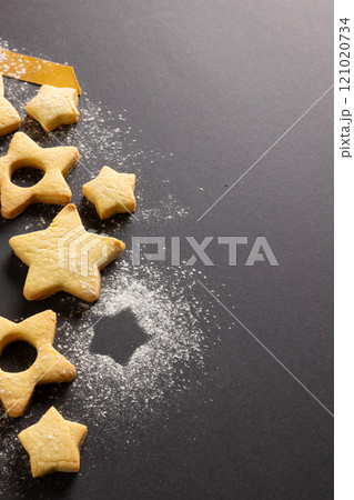 Vertical image of close up of christmas cookies with copy space and ribbon on black background 121020734