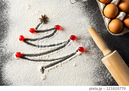Anis seed and christmas tree shape in flour, eggs, roller with copy space on black background 121020770