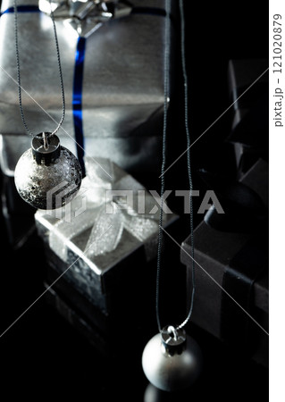 Vertical image of silver christmas baubles and gifts with copy space on black background Vertical image of silver christmas baubles and gifts with copy space on black background 121020879