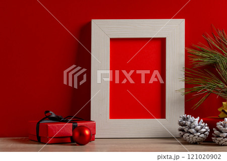 Christmas decorations and wooden frame with copy space on red background 121020902