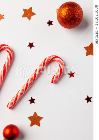 Vartical image of christmas red baubles, stars and candy canes with copy space on white background Vartical image of christmas red baubles, stars and candy canes with copy space on white background 121021039