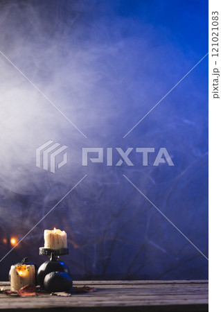 Vertical image of pumpkins and candles with copy space on dark background Vertical image of pumpkins and candles with copy space on dark background 121021083