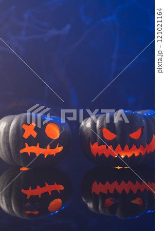 Vertical image of carved pumpkins with copy space on blue background 121021164