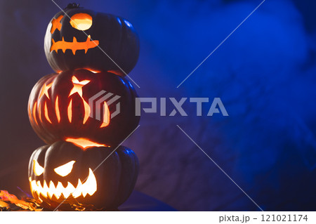 Carved pumpkins with copy space on blue background Carved pumpkins with copy space on blue background 121021174